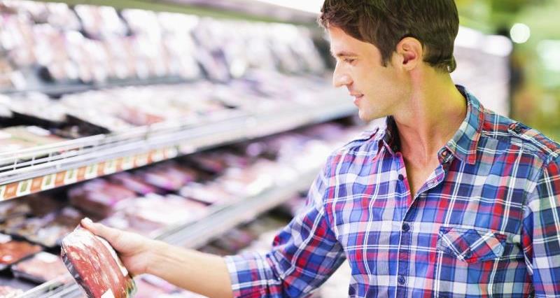 Man looking at meat in a supermarket