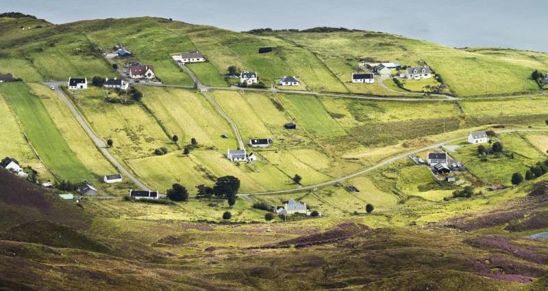 Rolling hills with cottages and farm houses running through them.