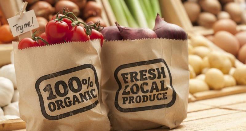 Two paper bags, one with organic food and one with local food