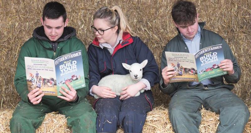 Students reading Student Farmer magazine and holding a lamb