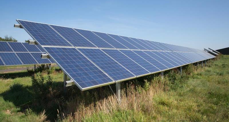 A set of solar panels in a field of a farm. 