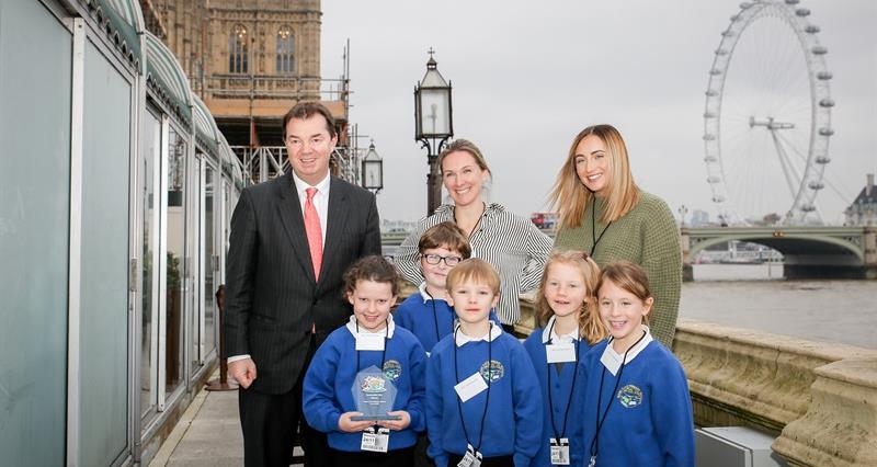 Guy Opperman MP with pupils and staff from Wark Primary School on the outdoor balcomy at the House of Commons with the River Thames and London Eye in the background