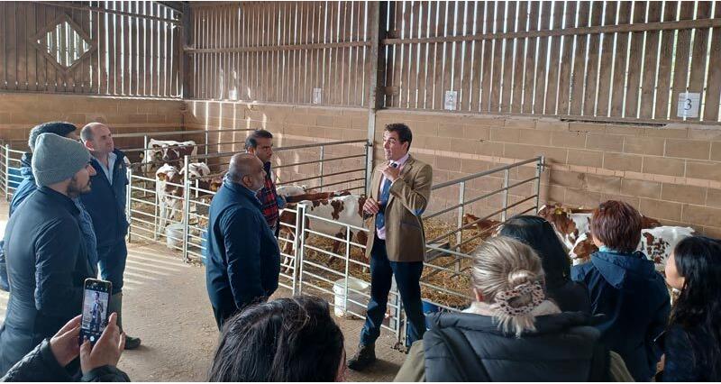 A group of export showcase visitors receiving a talk inside a cattle shed