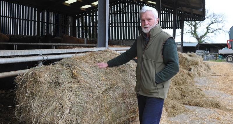 Tom Cowcher next to a bale of hay