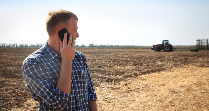 iStock man on phone in field with tractor_50839