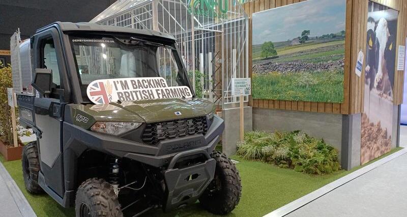 NFU party conference stand, including a gator utility vehicle, a glasshouse, hedges and a Back British Farming sign