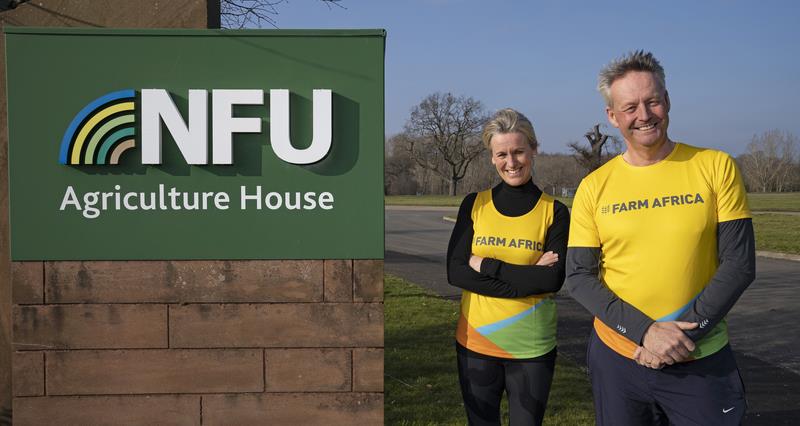 NFU President Minette Batters and Vice President David Exwood stand in yellow #FarmAfrica t-shirts and running gear next to the NFU HQ Sign.