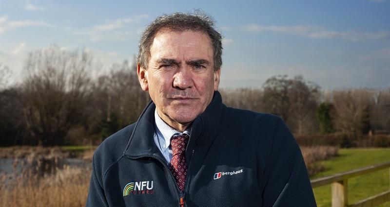An image of NFU Cymru President Aled Jones stood in front of a field