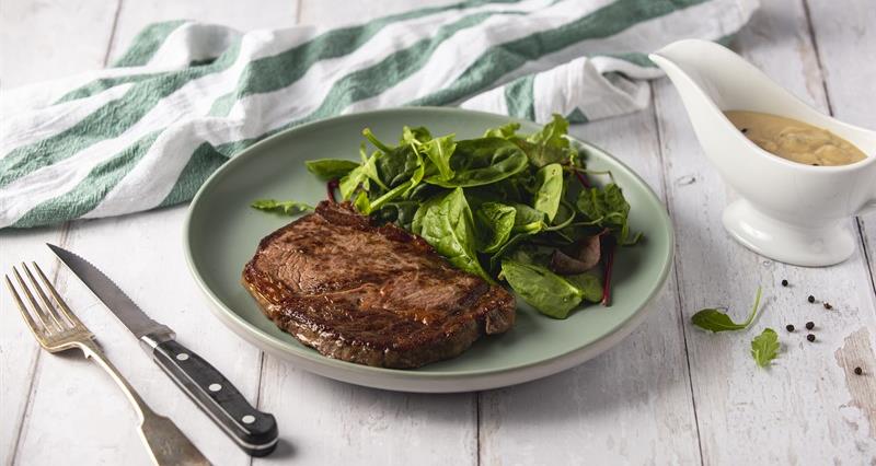 Beef steak with rocket, spinach and beetroot salad and peppercorn sauce.