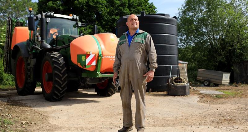 Matt Culley pictured at his farm stodd in front of a tractor