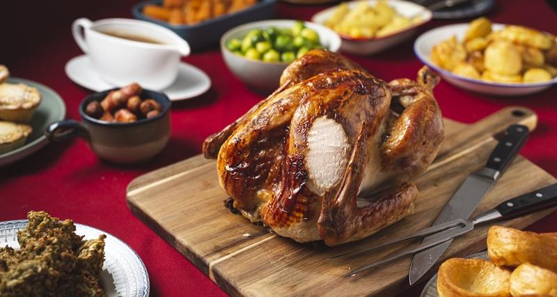 a picture of a cooked turkey alongside other Christmas dinner ingredients on a table