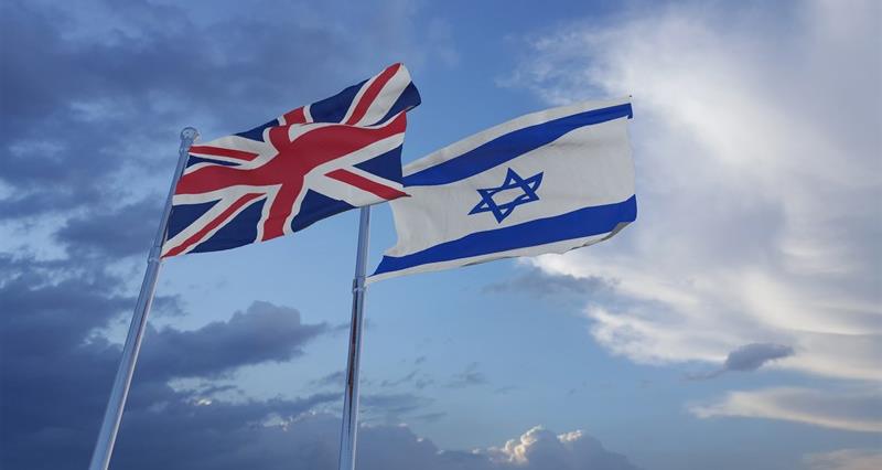 An image of the Union Jack and the Israel flag flying next to each other against the sky