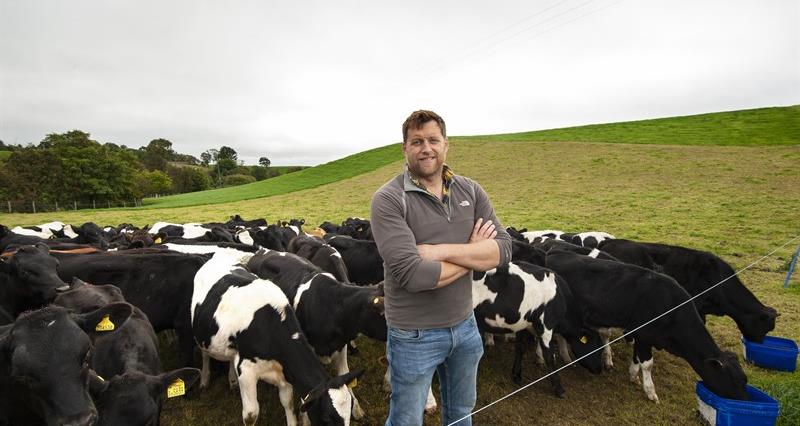 Llyr Jones on his farm in Denbighshire with his cattle behind him.