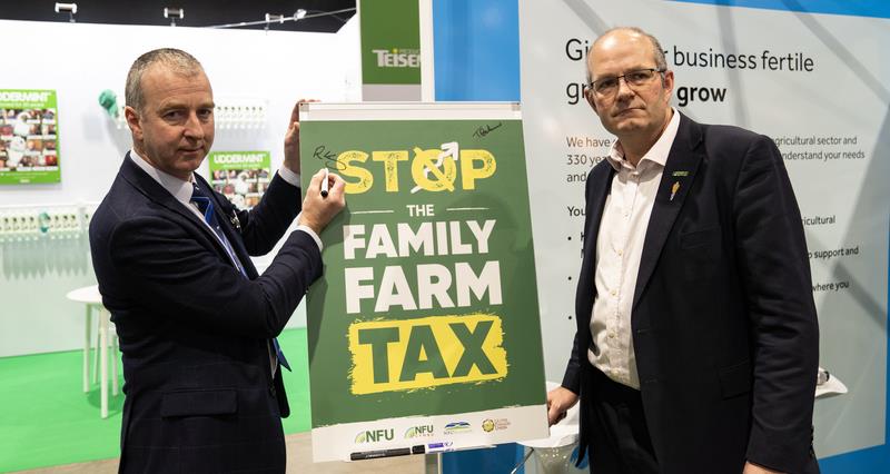 NFU President Tom Bradshaw and RABDF chair Robert Craig signing the Stop The Family Farm Tax campaign pledge board at DairyTech.