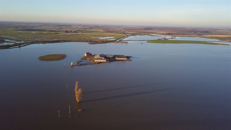 A farm in Lincolnshire completely submerged by water, with only the steading visible