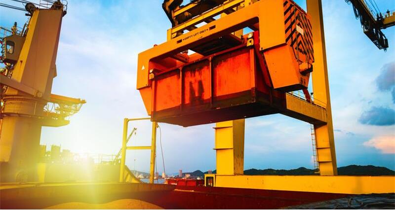 Raw sugar bulk loaded into large vessel hole by rotainer for export.