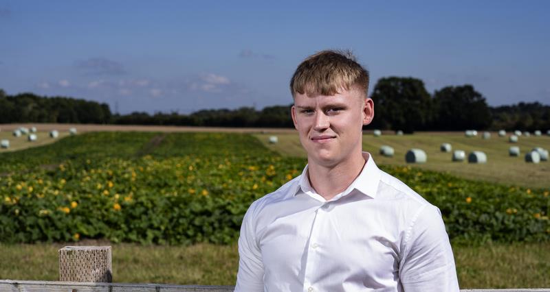 CT Planning's apprentice town planner, Will Varley, stood in front of an arable field.