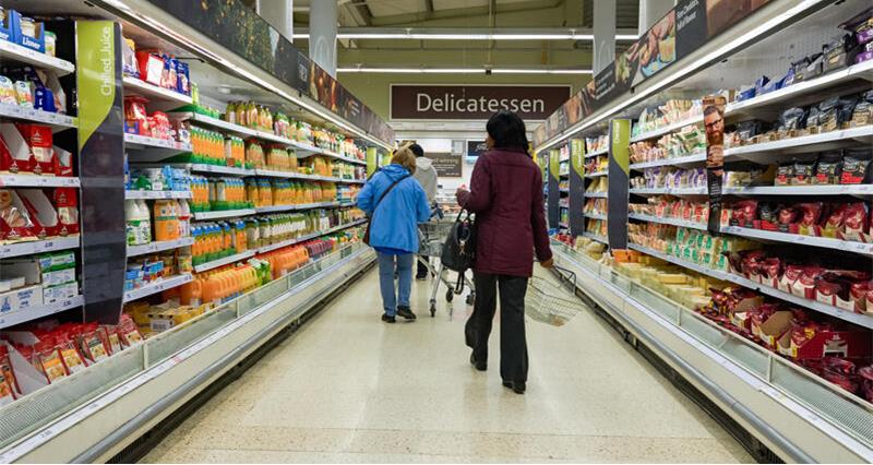 Shoppers walking down a supermarket aisle