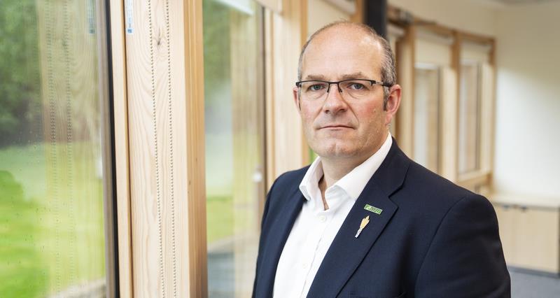 A picture of NFU President Tom Bradshaw stood in an office looking at the camera