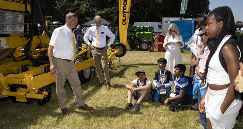 A photo of secondary school students at the Claydon Drills demo area at Cereals 2023, listening about seed drilling. 