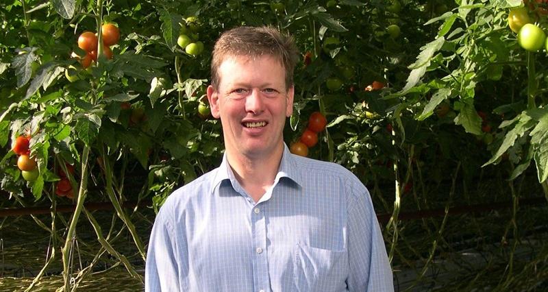An image of Phil Pearson stood in front of fruit trees