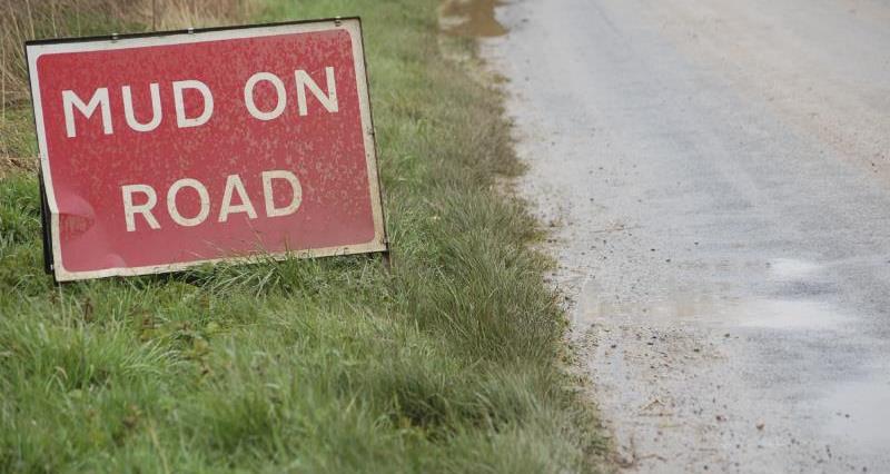 An image of a road sign warning of mud on the road