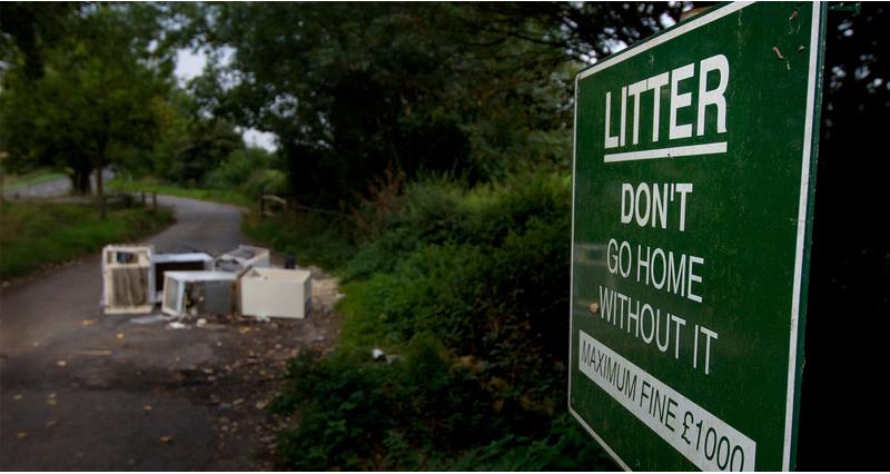An image of a council sign warning against littering with fly-tipped waste in the background.