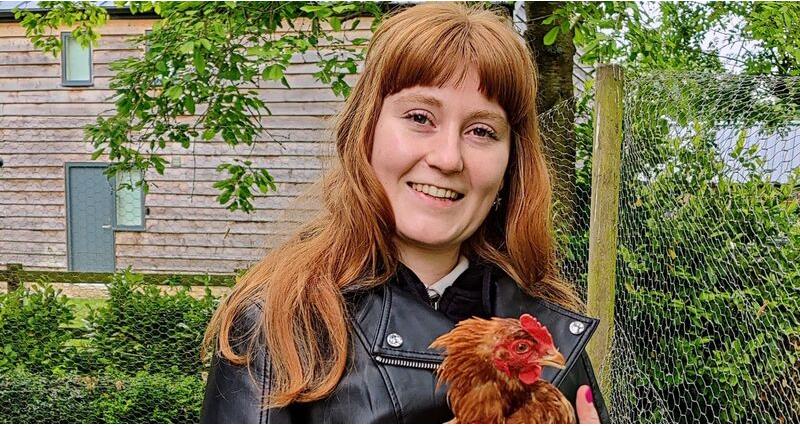 An image of student Maisie Bruce holding a rooster 