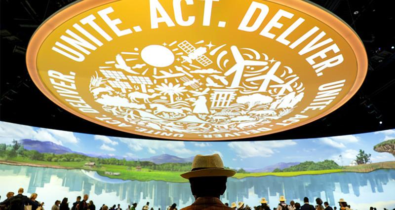 A farmer sat in front of the food, farming and agriculture day screen at COP28