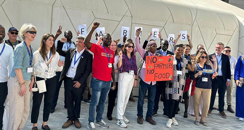 COP28 farming representatives holding a sign saying 'no farmers no food'