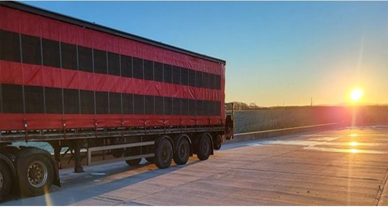 An image of a lorry with a sunset in the background