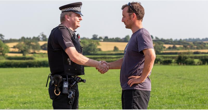 Policeman shaking hands with farmer