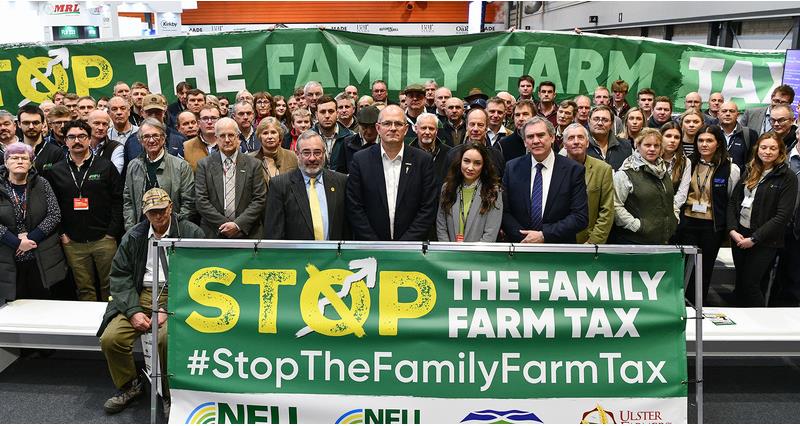 Tom Bradshaw and Aled Jones stood with a crowd of allied industries representatives and a stop the family farm tax banner