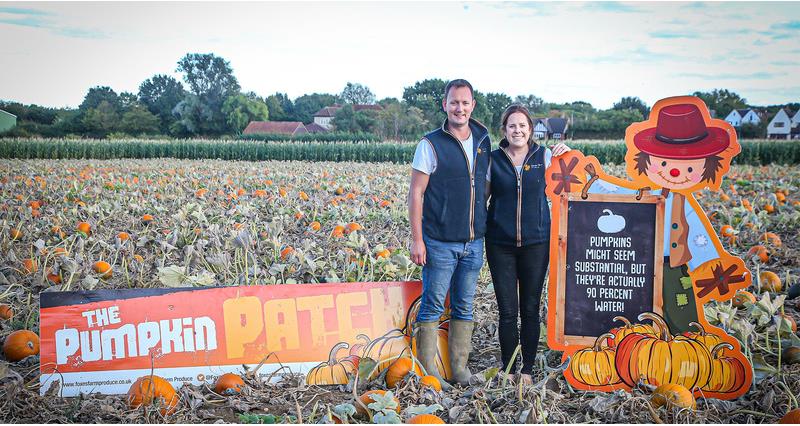 Emily and Guy French stood in a pumpkin field