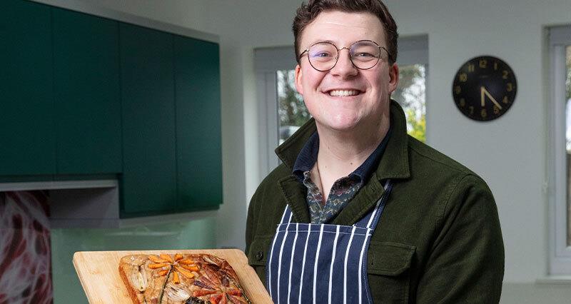 Mike Wilkins in his kitchen holding foccacia