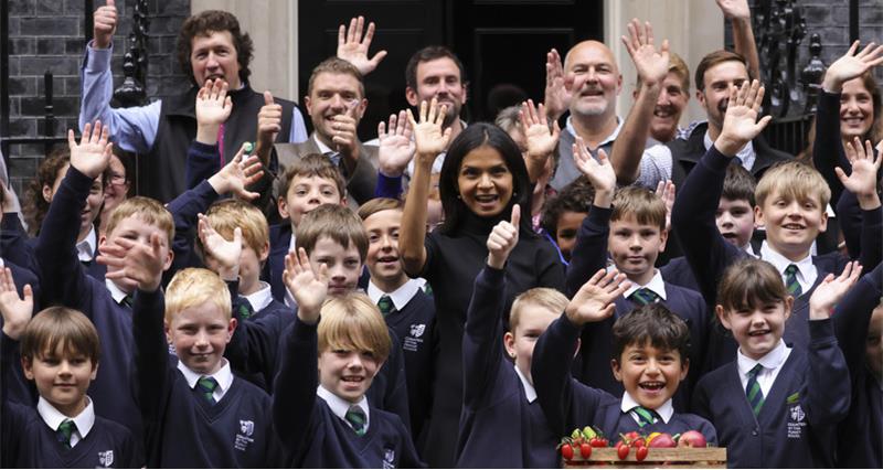 NFU Education, Akshata Murty, NFU Farmers for Schools Ambassadors and primary school students stand in front of 10 Downing Street.