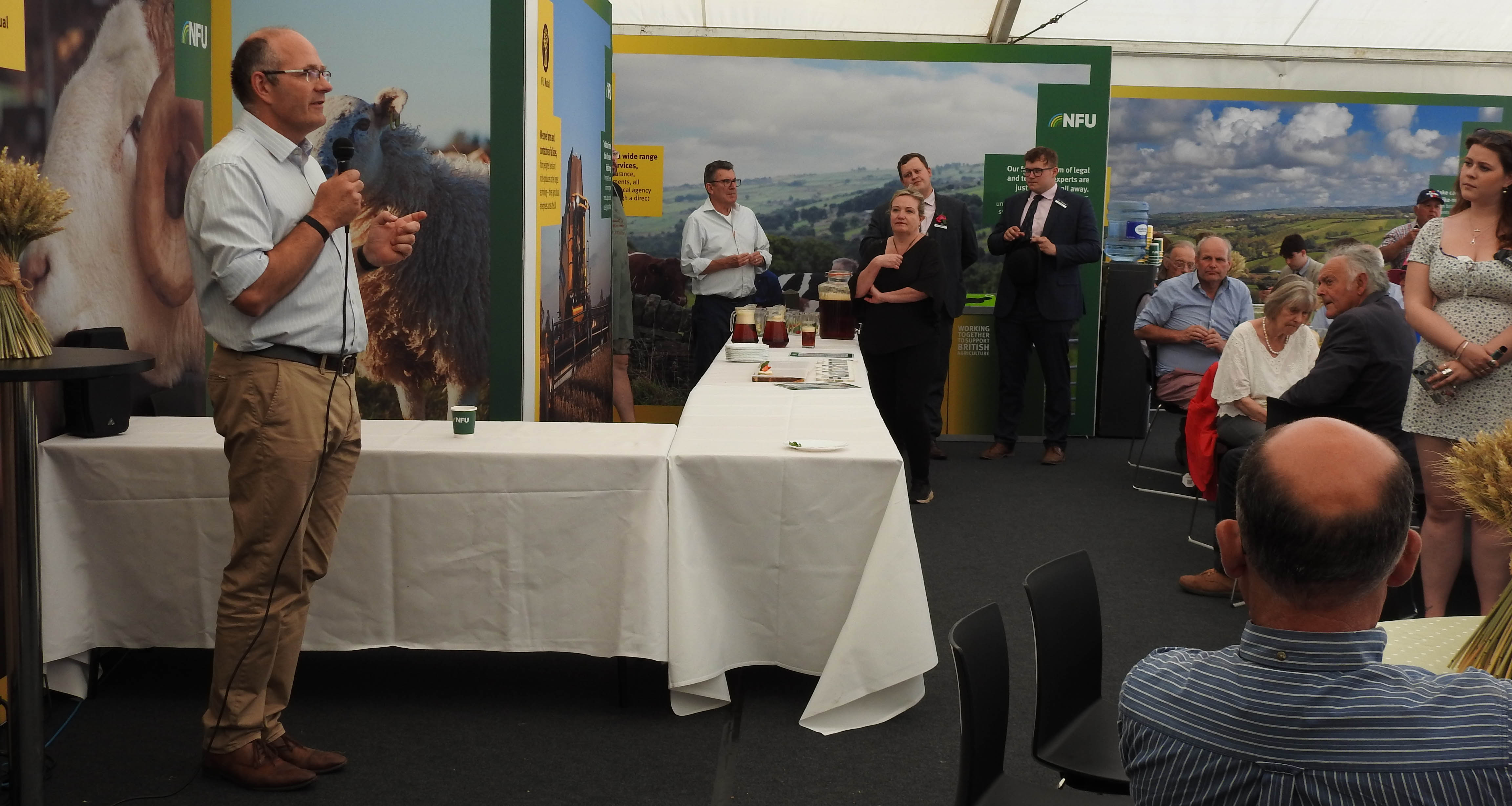 President Tom Bradshaw speaking to members inside a marquee