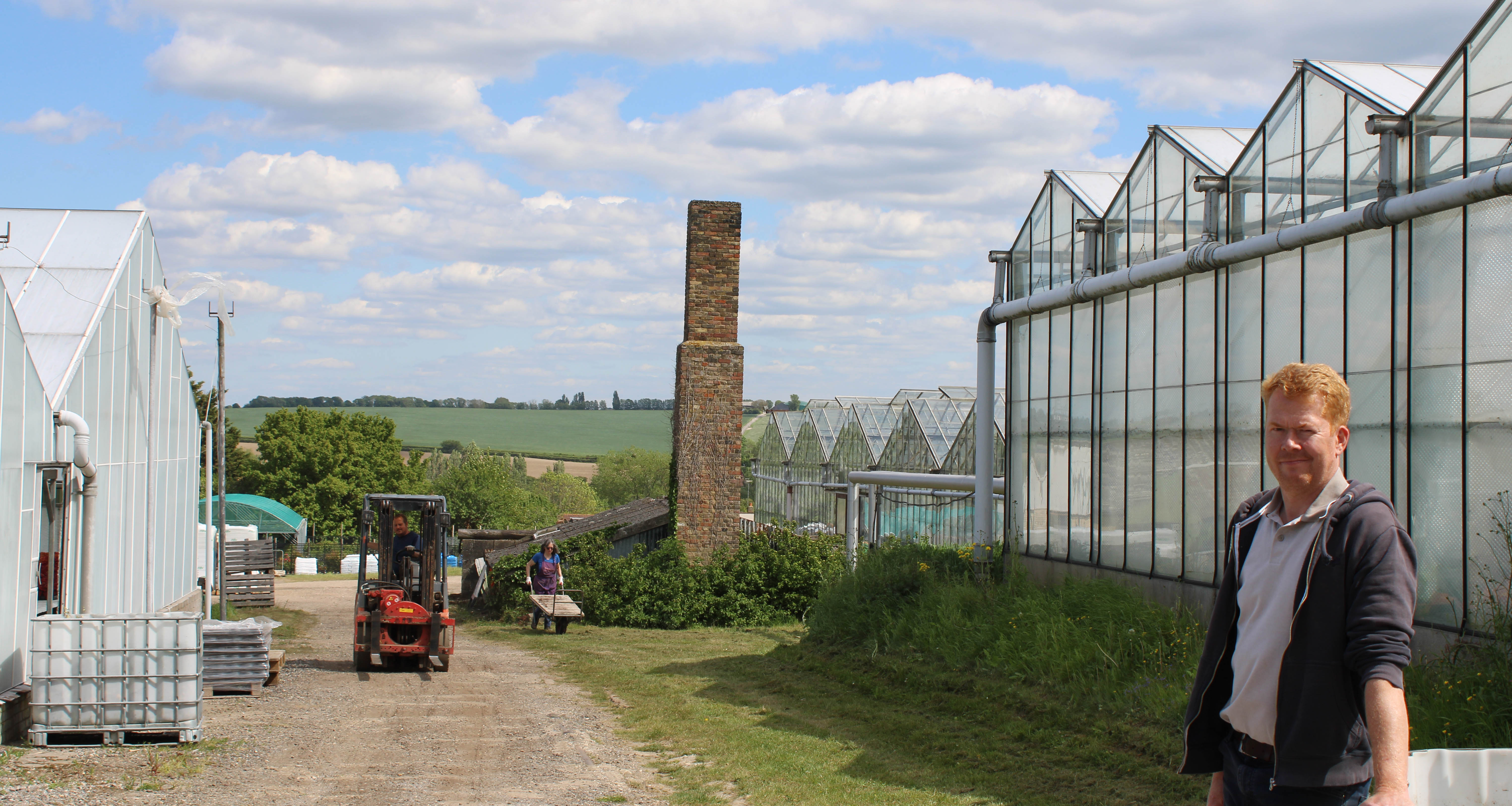 Ian Mills standing outside a glasshouse