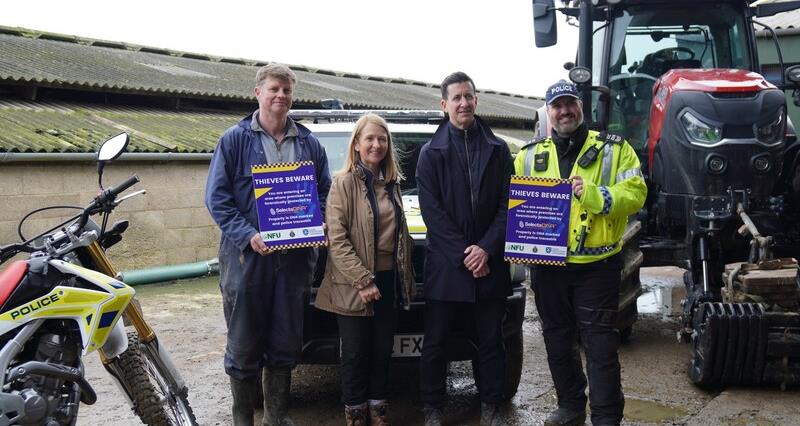 Police and the Police and Crime Commissioner standing in front of a tractor