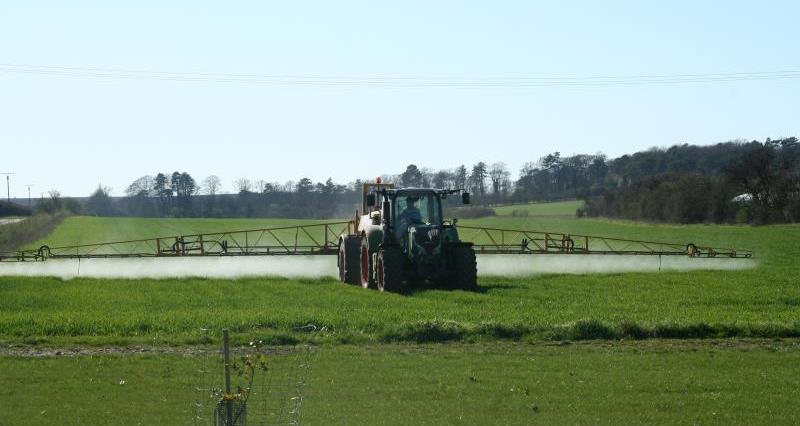 A picture of a tractor spraying crops