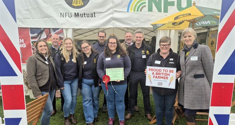 A group photo of NFU Kendal stood outside the NFU stand at Westmorland County Show