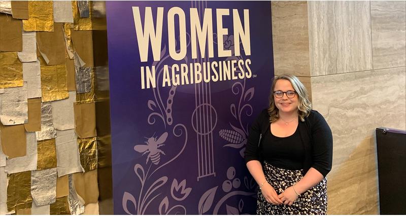 Niamh McGrath in front of a sign saying 'women in agribusiness'