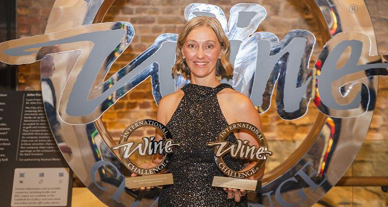 Head Winemaker Cherie Spriggs holding two trophies at the International Wine Challenge