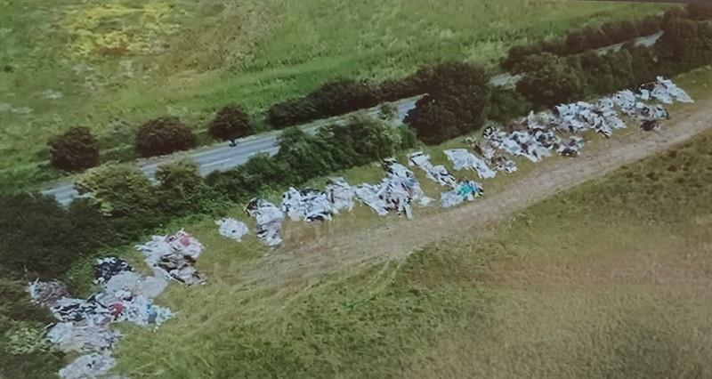 An aerial view of fly-tipping along the edge of a field