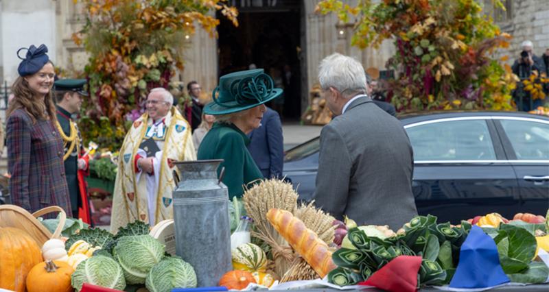 Peter Drinkwater speaking to the Queen behind a display of British produce