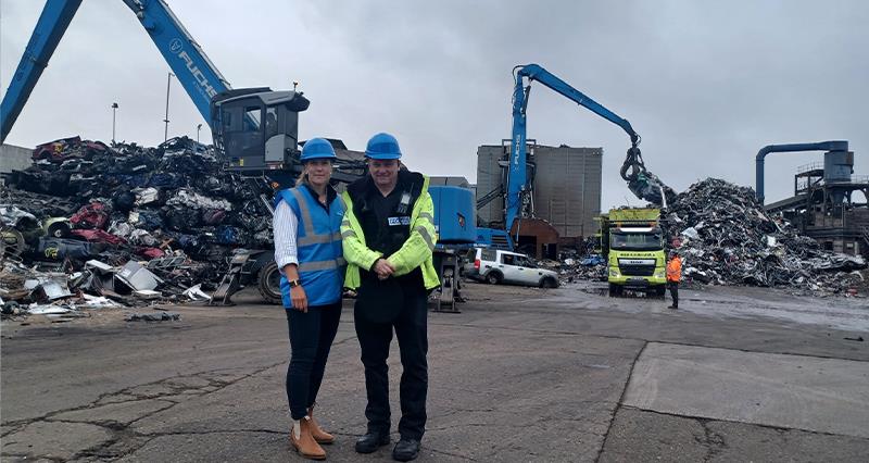 Farmer Ros David and a police officer standing in a wrecking yard