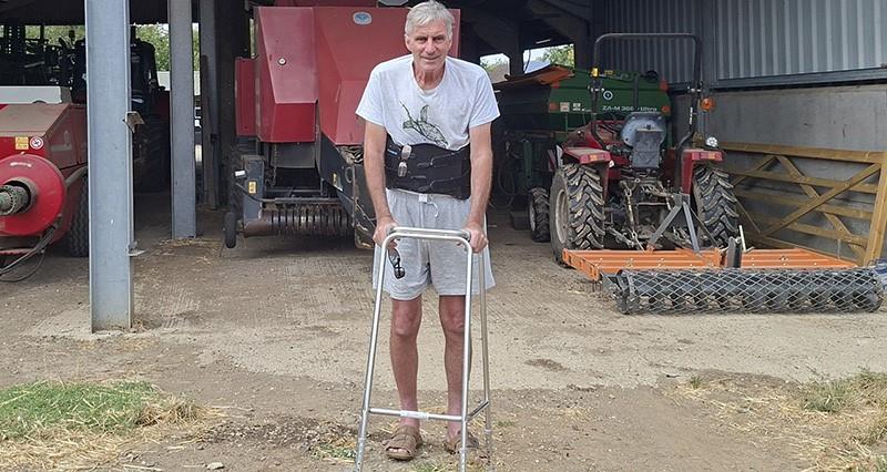 Will Dickinson stood on farm with a walking frame