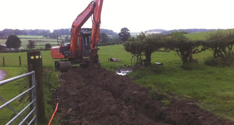 A digger digging up farmland